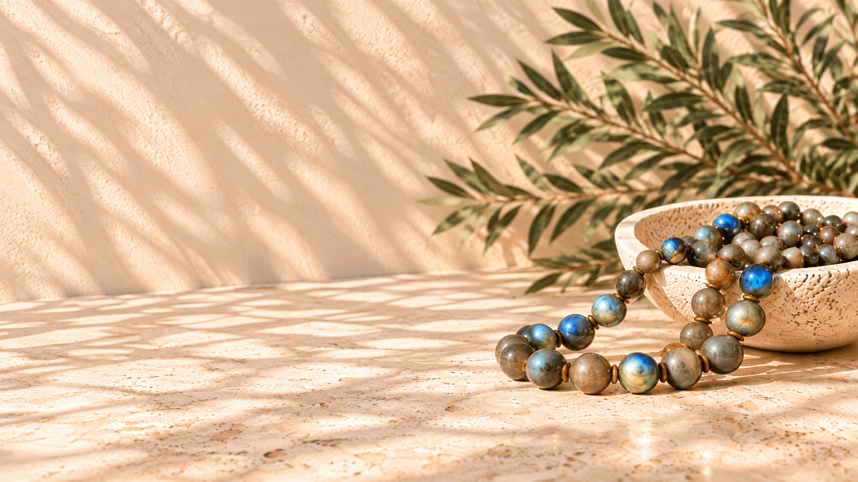 A gemstone necklace spilling from a ceramic bowl